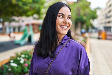 Wall Mural - Young beautiful hispanic woman smiling confident looking to the side at park