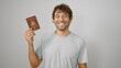 Cheerful young man joyfully flashing his philippine passport, standing confidently isolated against a pure white background