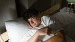 © Krakenimages.com - Young hispanic teenager comfortably lying on bed hugging pillow, lost in thoughts in cozy bedroom