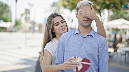 Sticker - Beautiful couple surprise with heart gift box smiling at street