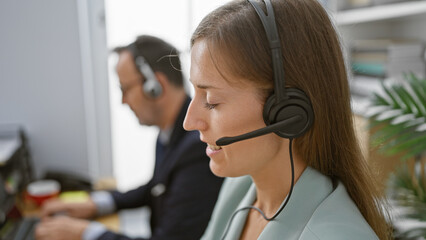 Wall Mural - Two upbeat call center agents working together, smiling with confidence in the business office