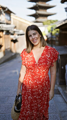 Sticker - Beautiful hispanic woman smiling joyfully, confidently posing, standing on the old traditional streets of gion, kyoto, her sunny, carefree nature shining through for a fun-filled japan adventure.