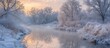 A river winds its way through a winter landscape, flanked by trees blanketed in snow. The icy sunrise casts a golden glow on the canaled foliage.
