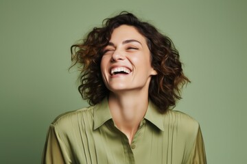 Wall Mural - Portrait of a happy young woman laughing, isolated on green background