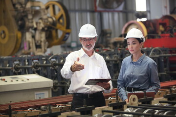 Wall Mural - worker or engineer working in factory with safety uniform , safety hat and safety glasses , image is safety concept or happy workplace