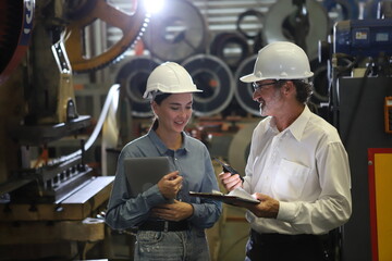 Wall Mural - worker or engineer working in factory with safety uniform , safety hat and safety glasses , image is safety concept or happy workplace