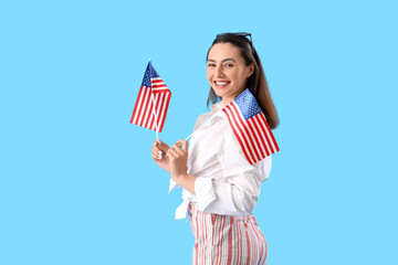 Wall Mural - Young woman with USA flags on blue background