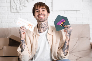 Sticker - Young tattooed man with gift cards at home