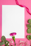 Kartka papieru w ramie z naturalnych kwiatów. Na różowym tle z miejscem na tekst. 