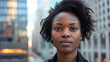 © Alexandre - Retrato de uma mulher afroamericana com expressão preocupada em frente a um cenário urbano capturado em close com lente 50mm
