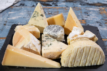 Tasting plate with small pieces of different French cheeses, variety of cheeses