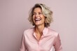 © Inigo - Portrait of a beautiful middle aged woman laughing against a pink background