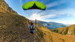 Extreme paraglider pilot flying over New Zealand mountains, adventure concept.