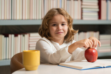 Poster - Pupil read book. School kid pupil studying in school library. Child reading book in library on bookshelf background.