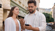 © Yuliia - Caucasian young couple upset bad news mobile phone failure loss disappointed man woman city outside reading message street frustrated problem trouble stressed together looking at gadget screen worried