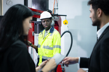 Technicians are introducing industrial hand robots to businessperson of factory industry who will use them in large-scale complex manufacturing operations.