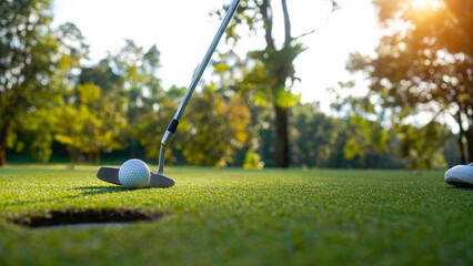 Wall Mural - Golfer playing golf in the evening golf course, on sun set evening time.