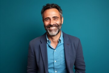 Wall Mural - Portrait of a handsome middle-aged man smiling against blue background
