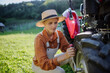 Female farmer fixing a wheel on a tractor. Progressive farmer working on tractor on her own farm. Women in agriculture.