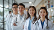 © aekkorn - group of smiling Asian male doctors and smiling Asian female doctors standing together. set scene at modern meeting room on big glass windows background in noon at hospital.
