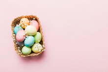 Happy Easter Composition. Easter Eggs In Basket On Colored Table With Gypsophila. Natural Dyed Colorful Eggs Background Top View With Copy Space