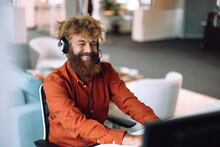 Happy Businessman Wearing Headset And Working On Computer In Office