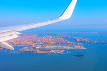 Plane Flying Above Venice Italy. View Of Airplane Wing Over Venice During Taking Off Or Landing.  Aerial View Of Venezia And Aircraft Wing