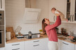 © Westend61 - Happy woman playing with baby girl in kitchen