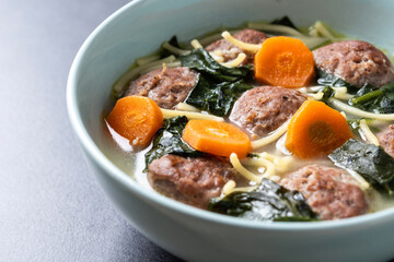 Canvas Print - Italian Wedding Soup with meatballs and spinach on black background. Close up