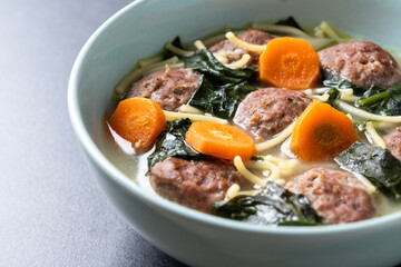 Wall Mural - Italian Wedding Soup with meatballs and spinach on black background. Close up