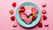 A plate full of heart-shaped cookies in varying pink hues evoke feelings of love, affection, and festive celebration
