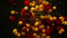 Background video showing sea buckthorn and cranberry falling into the water. Small berries seem to dance among themselves in the liquid. High quality 4k footage