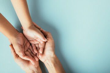 Wall Mural - Studio shot, Top view of family hands stacked on isolated background. Parents and kid hold empty space a gesture of support and love for Family and Parents Day.