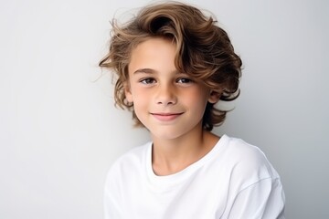 Wall Mural - Portrait of a cute little boy with curly hair. Studio shot.