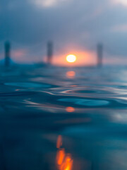 Wall Mural - close-up view of the water at dawn with sunlight.
