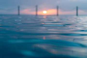 Wall Mural - close-up view of the water at dawn with sunlight.