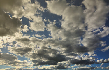 A blue cloudy sky with many small clouds blocking the sun