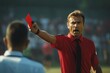 Referee showing red card to football player during match on stadium pitch closeup