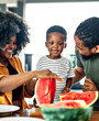 © Lumos sp - child family kitchen food boy son father mother watermelon fruit slice summer organic meal fun preparing healthy diet eating home black