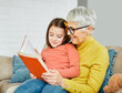 © Lumos sp - grandchild family child grandparent grandmother book reading elderly granddaughter girl  happy together read learning education woman