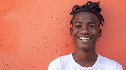 Poster - A young man with a bright smile and curly hair wearing a white t-shirt standing against a textured orange wall.