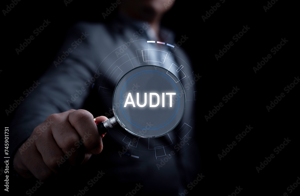 Hand holding magnifier glass with audit wording for ISO quality audit ...