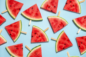 Canvas Print - Watermelon slice popsicles on a blue background