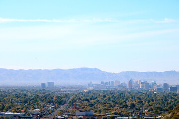 Wall Mural - High rise buildings of Phoenix downtown in the Valley of the Sun with a backdrop of South Mountains as seen from North Mountain Park hiking trails on a sunny Spring morning, Arizona