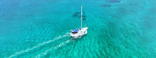 Wall Mural - Aerial drone ultra wide photo of sail boat anchored in tropical exotic turquoise calm waters forming a blue lagoon