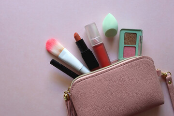 Wall Mural - Pink make up bag with various beauty products. Pink background, top view.