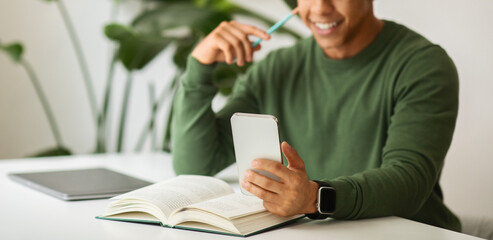 Sticker - Cropped of african american man sitting at table, using phone