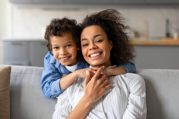 Wall Mural - Cheerful mother and son sharing hug and smile