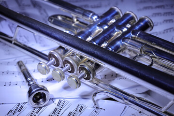 A view of the musical instrument which is the trumpet against the background of the sheet music