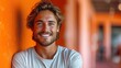 © Wall - a close up of a person with a smile on his face and a white t - shirt on and orange walls in the background and a man in the foreground.